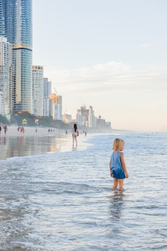 Little boy paddling in shallow water on the beach at the Gold Coast - Australian Stock Image