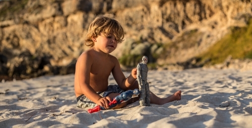 Little boy playing with toys at beach - Australian Stock Image