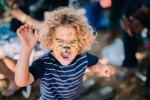 Little boy roaring with face paint
