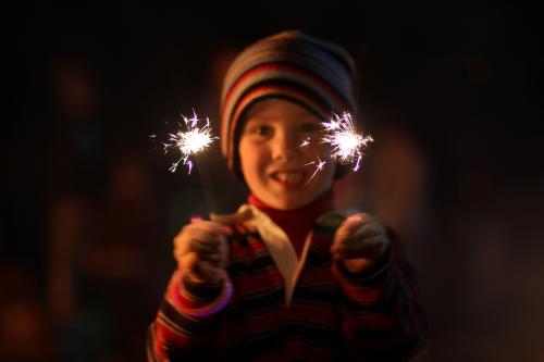 Little boy waving sparklers on a bonfire night