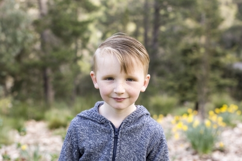 Little boy wearing jacket while standing outdoors. - Australian Stock Image