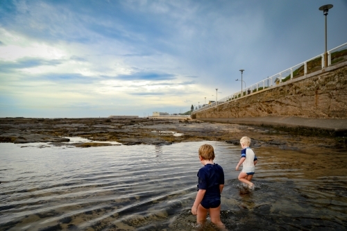 Little boys paddling in shallow water at Nobby's Beach, Newcastle - Australian Stock Image