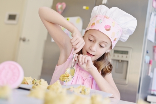 little girl baking at home in the kitchen - Australian Stock Image