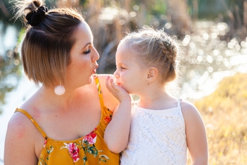 Little girl blowing her mum kisses - Australian Stock Image