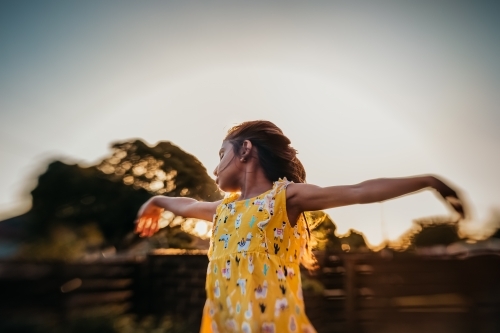 Little girl dancing during sunset - Australian Stock Image