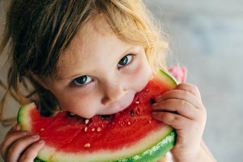Little girl eating watermelon - Australian Stock Image