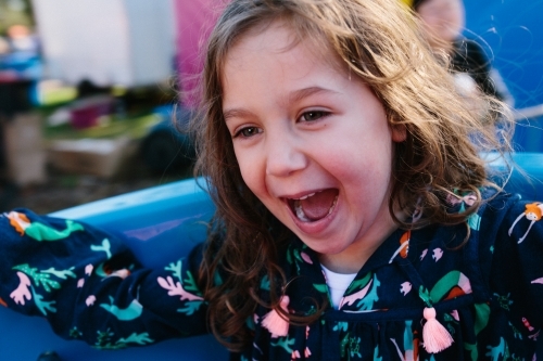 Little girl filled with joy on spinning ride - Australian Stock Image