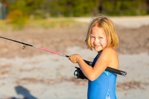 Little girl fishing at the beach - Australian Stock Image