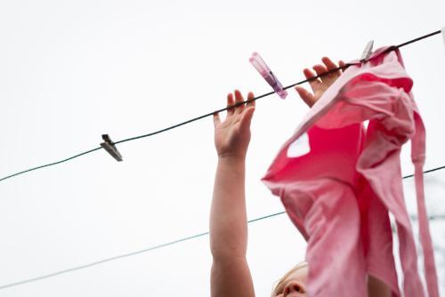 Little girl hanging clothes on the line