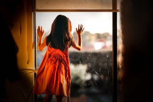 Little girl looking out the window - Australian Stock Image