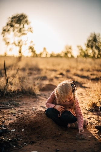 Little girl playing in the dirt on farm