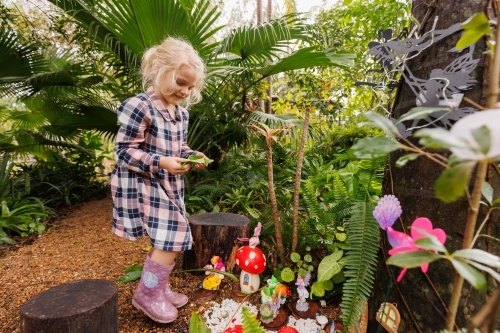 Little girl playing in tropical fairy garden - Australian Stock Image