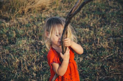 Little girl playing with a stick