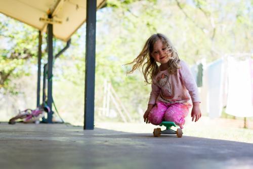 Little girl riding her skateboard - Australian Stock Image