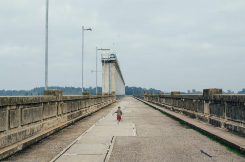 Little girl running at top of Hume Dam