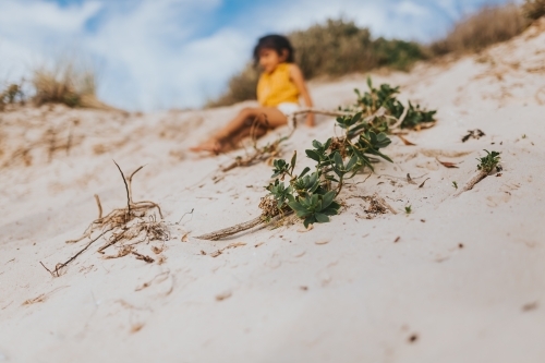 Little girl sliding down sand dunes
