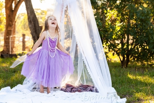 little kid playing imagine game dressed up as princess in purple dress - Australian Stock Image