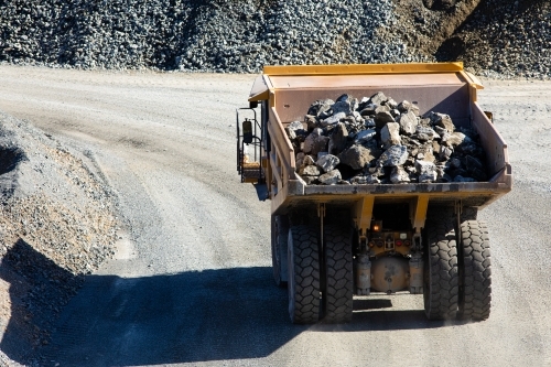 Loaded dump truck moving rock at a quarry mine - Australian Stock Image