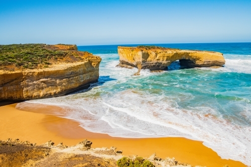 London Bridge along the Great Ocean Road showing the beach and coast - Australian Stock Image