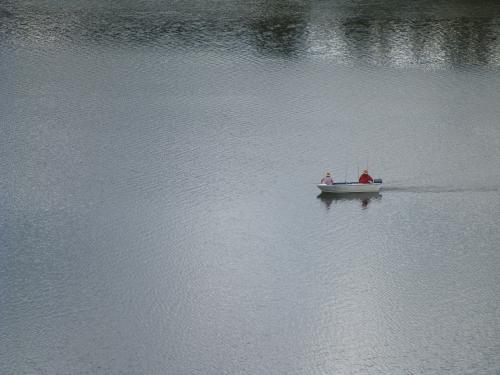 Lone boat motoring across a body of water - Australian Stock Image