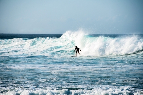 Lone surfer silhouette on wave - Australian Stock Image