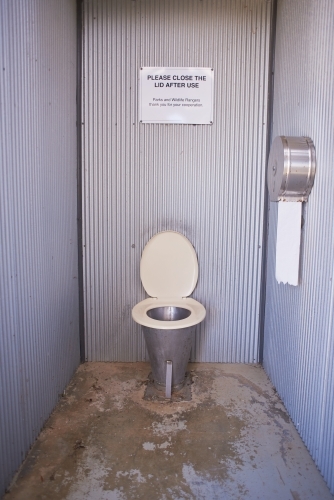 Long drop public toilet in a remote picnic area, with toilet paper. - Australian Stock Image