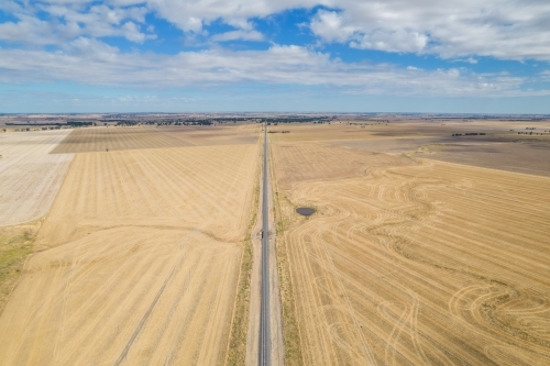 Long empty road surrounded by dry empty paddocks in the Mallee. - Australian Stock Image