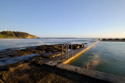 Long exposure of a swimmer in the ocean pool at Yamba - Australian Stock Image