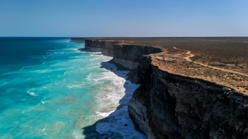 Long stretch of towering cliffs with deep turquoise waters. - Australian Stock Image