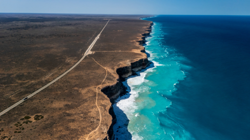 Long stretch of towering cliffs with deep turquoise waters. - Australian Stock Image