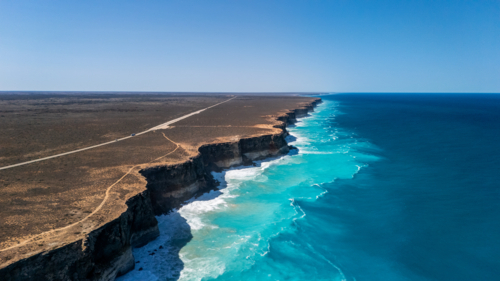 Long stretch of towering cliffs with deep turquoise waters. - Australian Stock Image