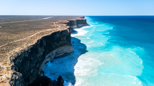 Long stretch of towering cliffs with deep turquoise waters. - Australian Stock Image