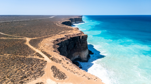 Long stretch of towering cliffs with deep turquoise waters. - Australian Stock Image
