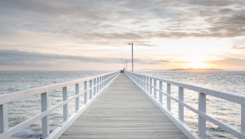 Long white pier at sunrise