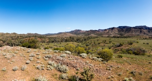 looking across green valley to rugged hills - Australian Stock Image