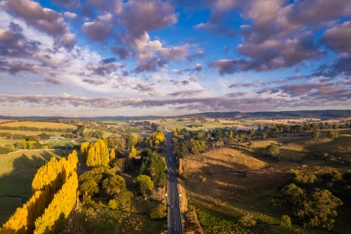 Looking down at an autumn countryside with poplar trees along the highway - Australian Stock Image