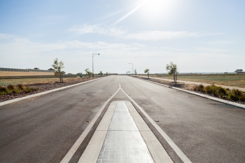 Looking down new road with empty blocks on either side - development - Australian Stock Image