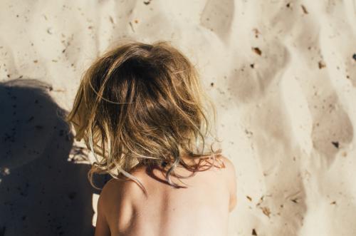 Looking down on a small child playing at the beach - Australian Stock Image