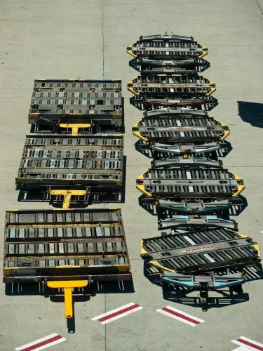 Looking down on aeroplane cargo trolleys parked at an airport