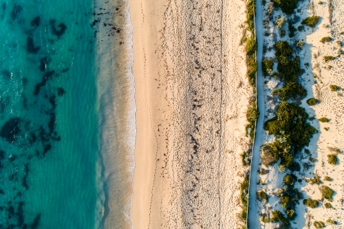 Looking down on ocean, beach, and coastal pathway.