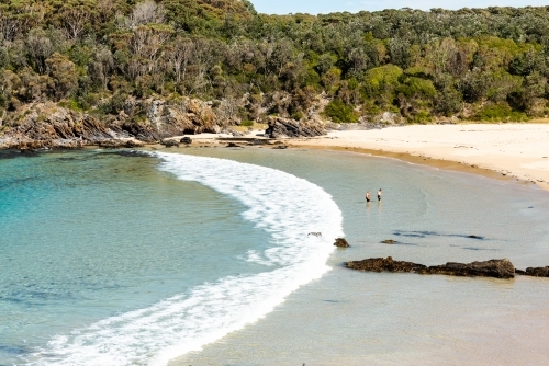 Looking down on picturesque cove and beach with people - Australian Stock Image