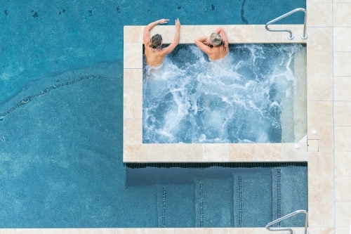 Looking down on two women relaxing in a bubbling spa - Australian Stock Image