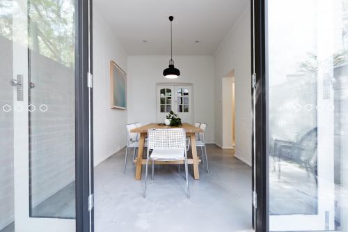 Looking into contemporary scandi styled dining room through french doors from courtyard - Australian Stock Image