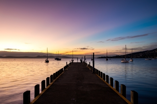 Looking out along a wharf to a sunset - Australian Stock Image