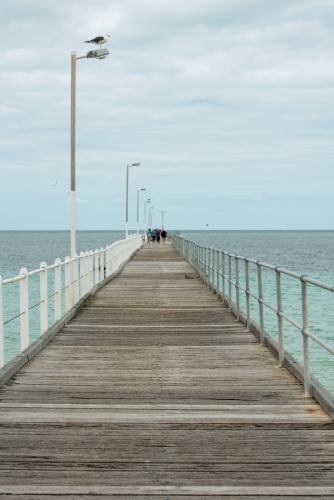 Looking out along a wharf with people at the end of the wharf