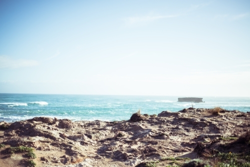 Looking out over rocky coastline to green ocean - Australian Stock Image