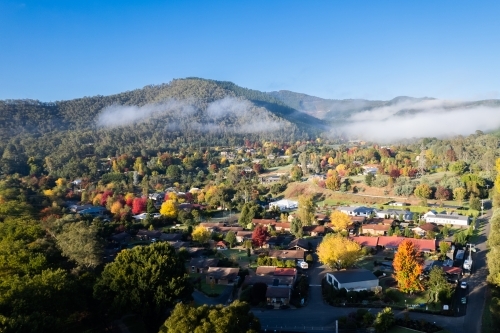 Looking over a town filled with autumn trees on a blue sky day - Australian Stock Image
