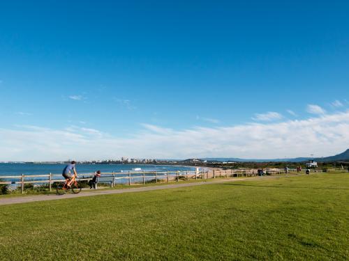 Looking south to Wollongong with cyclist on the cycle path - Australian Stock Image
