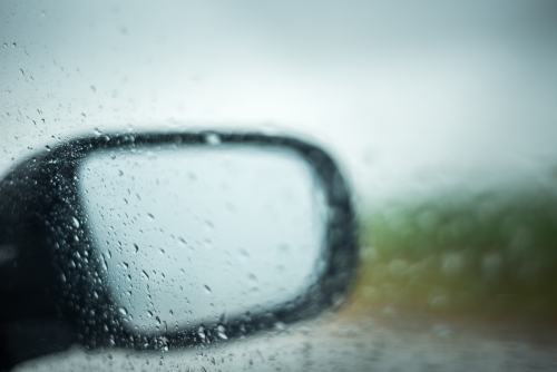 Looking through car window at side mirror in the rain