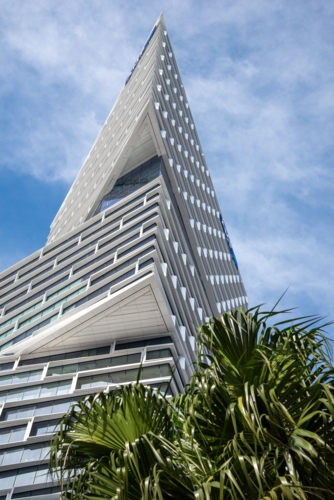 Looking up at a modern sky-scraper building on a sunny day - Australian Stock Image